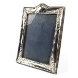 A 20th century silver photo frame, of rectangular form, decorated with floral swaggs of flowers,