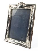 A 20th century silver photo frame, of rectangular form, decorated with floral swaggs of flowers,