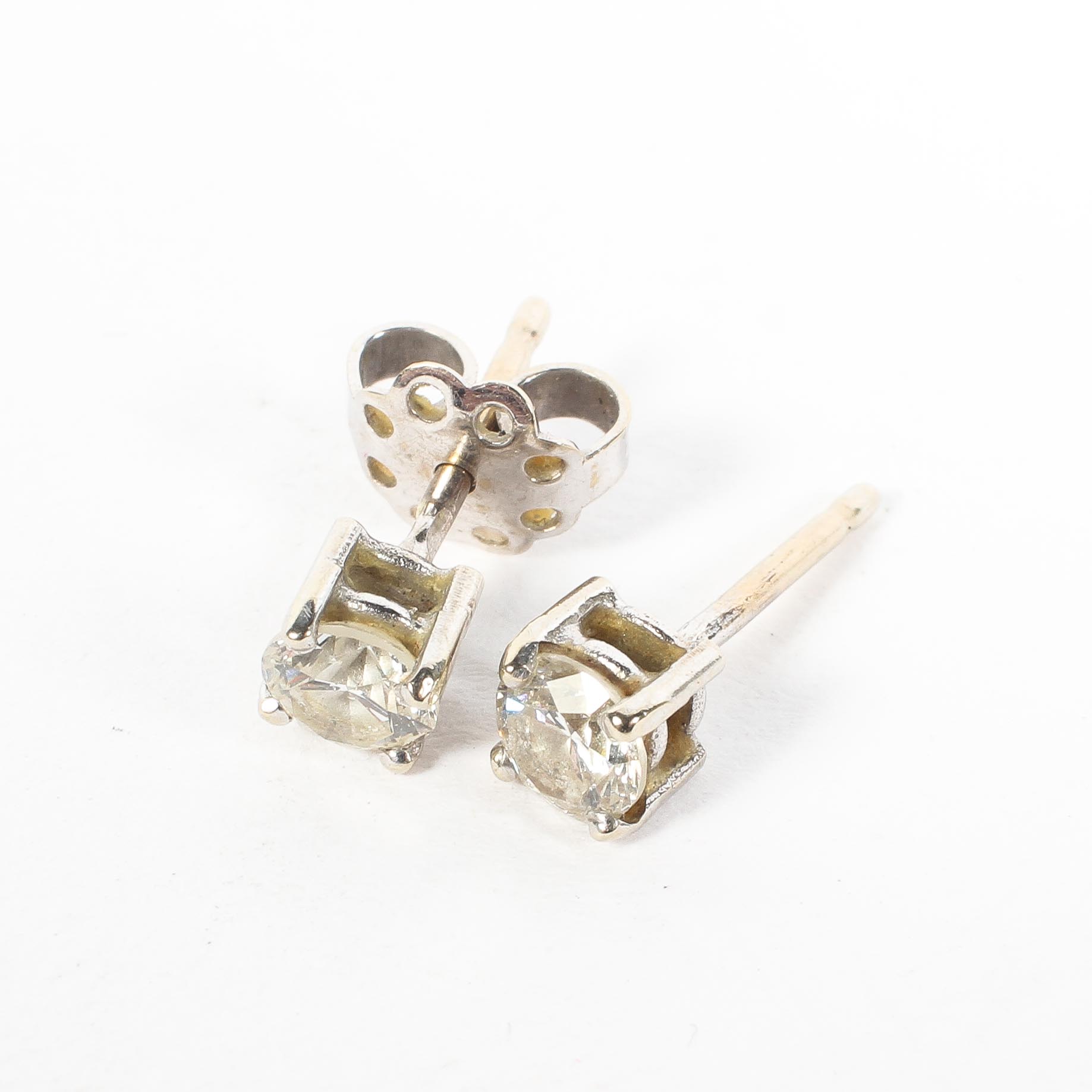 Two diamond stud earrings, each measuring 0.