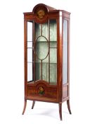 An Edwardian painted Sheraton style glazed display cabinet with arched pediment,