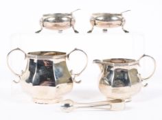 A matching silver sugar bowl and cream jug with two open salts and a set of sugar tongs,