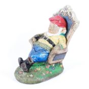 A large garden figure of a seated gnome with original painted decoration