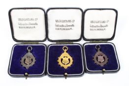 Three music association medals of consecutive dates, 1933-1935, gold silver and bronze, all cased,