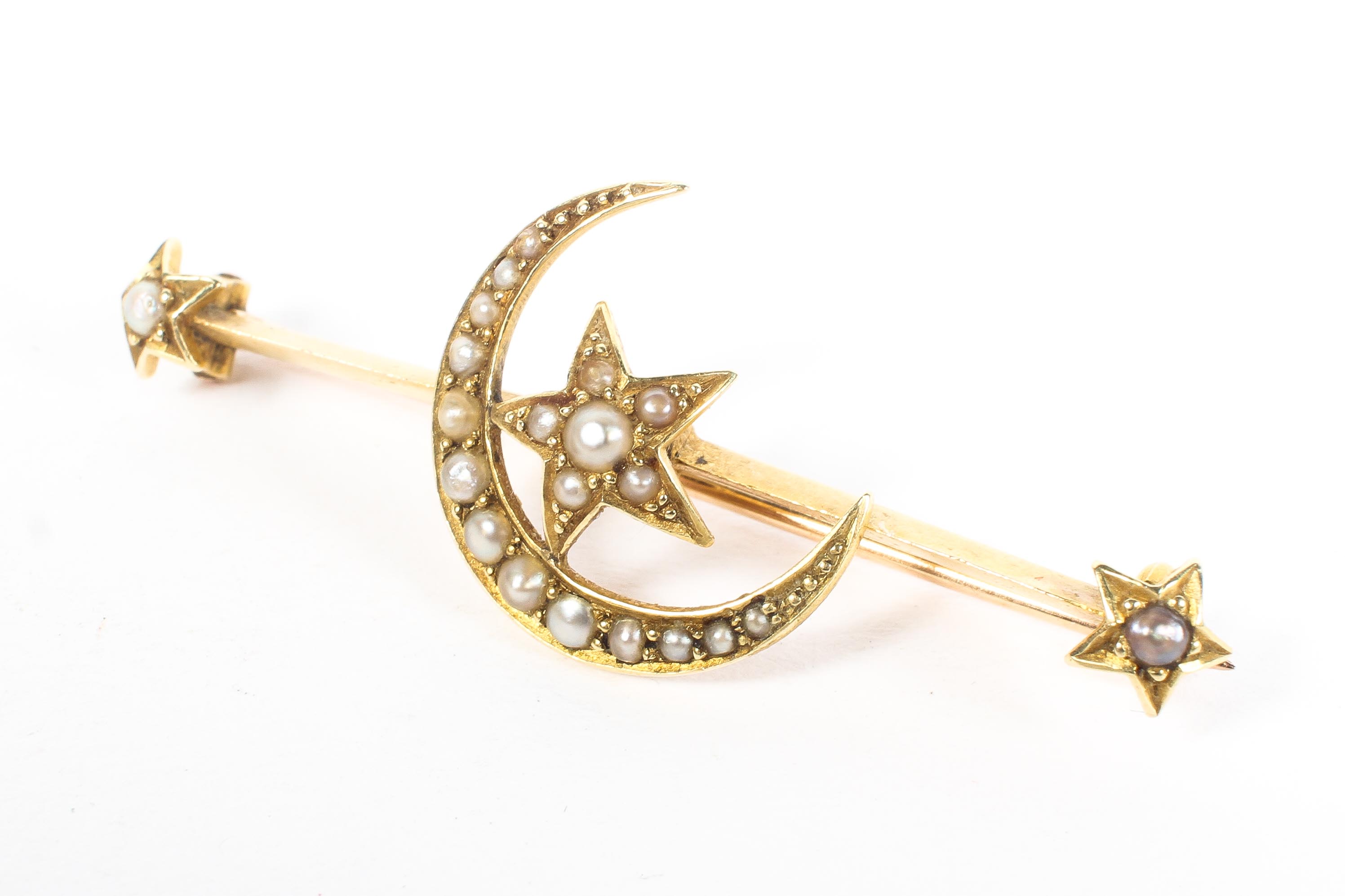 A 15ct yellow gold crescent moon and stars brooch, set with split pearl accents, 3.
