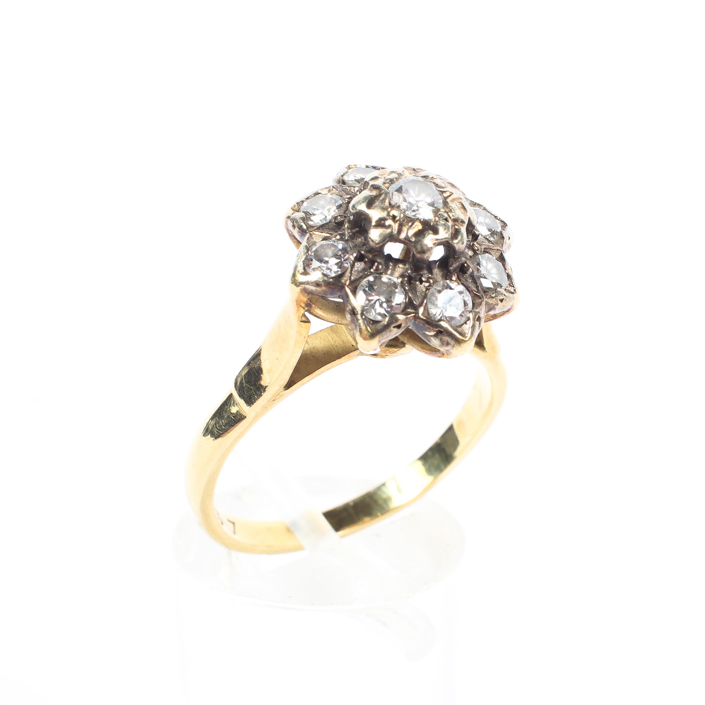 An 18ct gold and diamond cluster ring, set with nine brilliant cut diamonds, central stone approx 0.