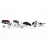 A collection of five silver pin cushions, to include a Pig, shoe, Boat and two Birds,