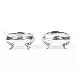 Two George V silver open salts, each being raised upon four feet,