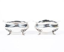 Two George V silver open salts, each being raised upon four feet,