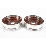 A pair of contemporary silver wine bottle coasters,