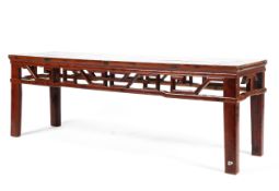 A late 19th century cherry wood elongated table with pierced geometric frieze raised on square