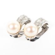 A pair of unmarked white metal diamond and pearl earrings, each set with single 7.