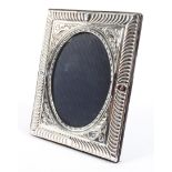 A contemporary silver picture of oval design, with foliate decoration,