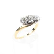 An 18ct gold three stone diamond ring, the three cut diamonds in an illusion setting, 3.