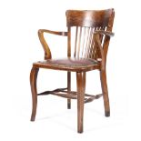 An arts and crafts oak elbow chair with square spindles,