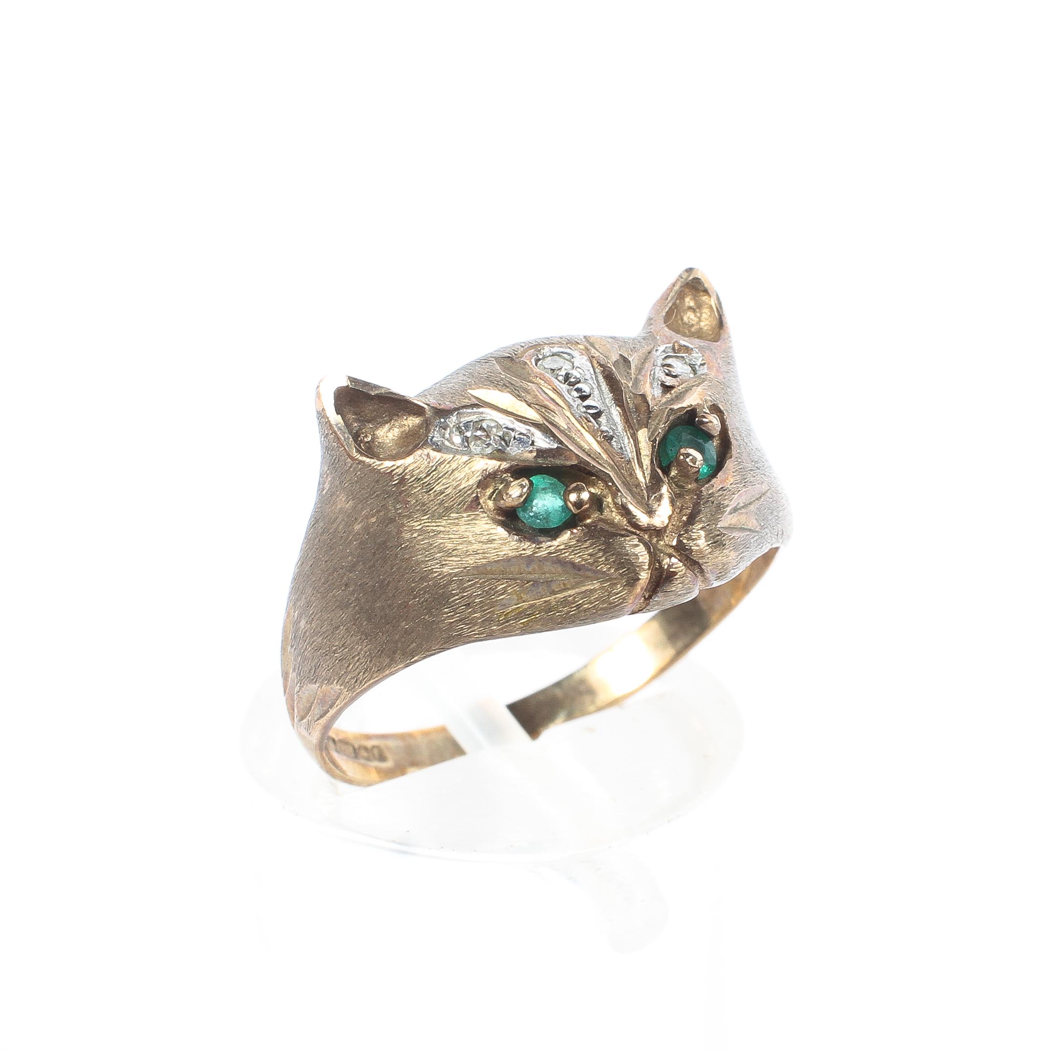 A 9ct gold ring, in the form of a cat's head, set with emerald eyes and single cut diamond accents,