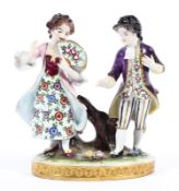 A continental porcelain figural group of a lady with fan in pink and a gentleman in purple jacket.