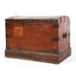 An early Victorian domed top iron-bound trunk on plinth base, with carry handles,