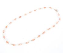 A 9ct gold, pink coral and freshwater pearl necklace. 38cm.