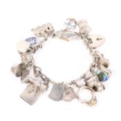 A sterling silver charm bracelet set with numerous silver and white metal charms. 47g.