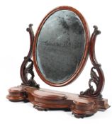 A Victorian mahogany oval swing mirror flanked by accanthuis supports above three lidded