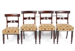 Four mid-19th century mahogany dining chairs, each top rail carved with scrolling leaves,