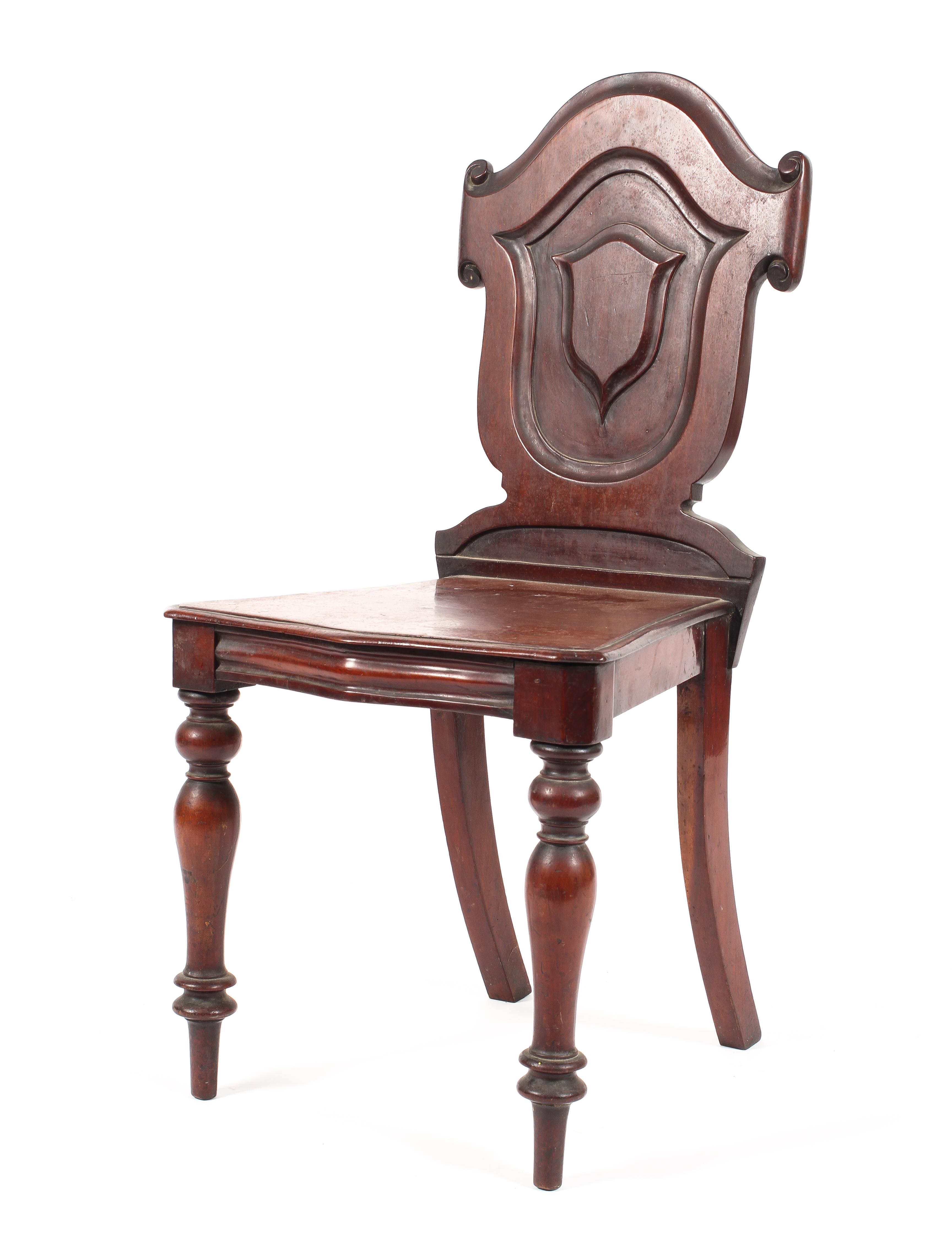 A Victorian mahogany sheildback hall chair raised on turned tapering front supports