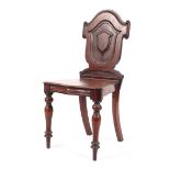 A Victorian mahogany sheildback hall chair raised on turned tapering front supports