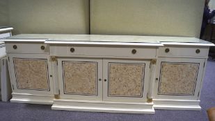 A large cream sideboard of stepped form with two short and one long drawer over cupboards,