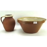 A large partially glazed wash bowl and jug, the basin measuring 36cm diameter,