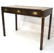 A 20th century stained wooden desk, three drawers with brass handles to the front,