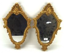 A pair of small wall mirrors, mounted in moulded gilt frames decorated with scrolls,
