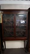 A 19th century mahogany display cabinet with geometric astragale glazed doors opening to reveal