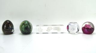 A collection of five glass paperweights, including examples by Caithness, Mdina,