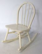 A child's wooden rocking chair, with curved back and turned spindles, painted cream,