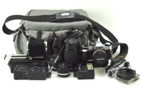Assortment of cameras and lenses including an Olympus camera and accessories