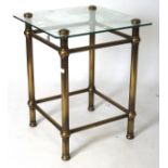 A contemporary glass topped side table, of square form, mounted on a brass frame,