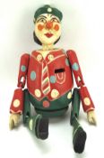 A contemporary painted wooden money box in the form of a clown,