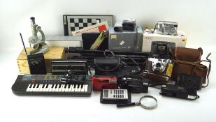 A collection of cameras and electronic equipment, including a tripod, Brownie camera,