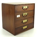 A miniature wooden chest of drawers, the four shelves of graduating size with brass handles, 30.