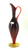 A large red and black art glass water pouring jug, of swirling form,