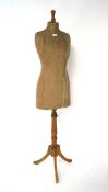 An early 20th century clothes mannequin, raised upon tripod base with cabriolet supports,