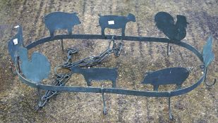 A vintage cast metal ceiling hanger, featuring the profiles of farm animals,