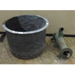 An antique metal pot and a water pump, both cast metal,