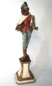 A contemporary figure of a Jester, dressed in traditional costume mounted on a octagonal base,