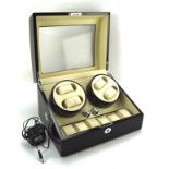 A contemporary watch winder, with slots for four watches and storage for a further six,