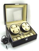 A contemporary watch winder, with slots for four watches and storage for a further six,