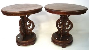 A pair of contemporary stained wood round top tables, the support with carved details,