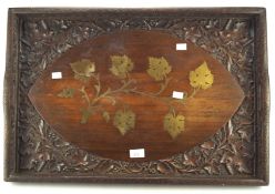 An early 20th century carved wooden butlers tray, with inlaid brass leaf motifs to the center,