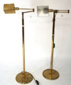 A pair of contemporary adjustable floor lamps, the cast brass frames mounted on circular bases,