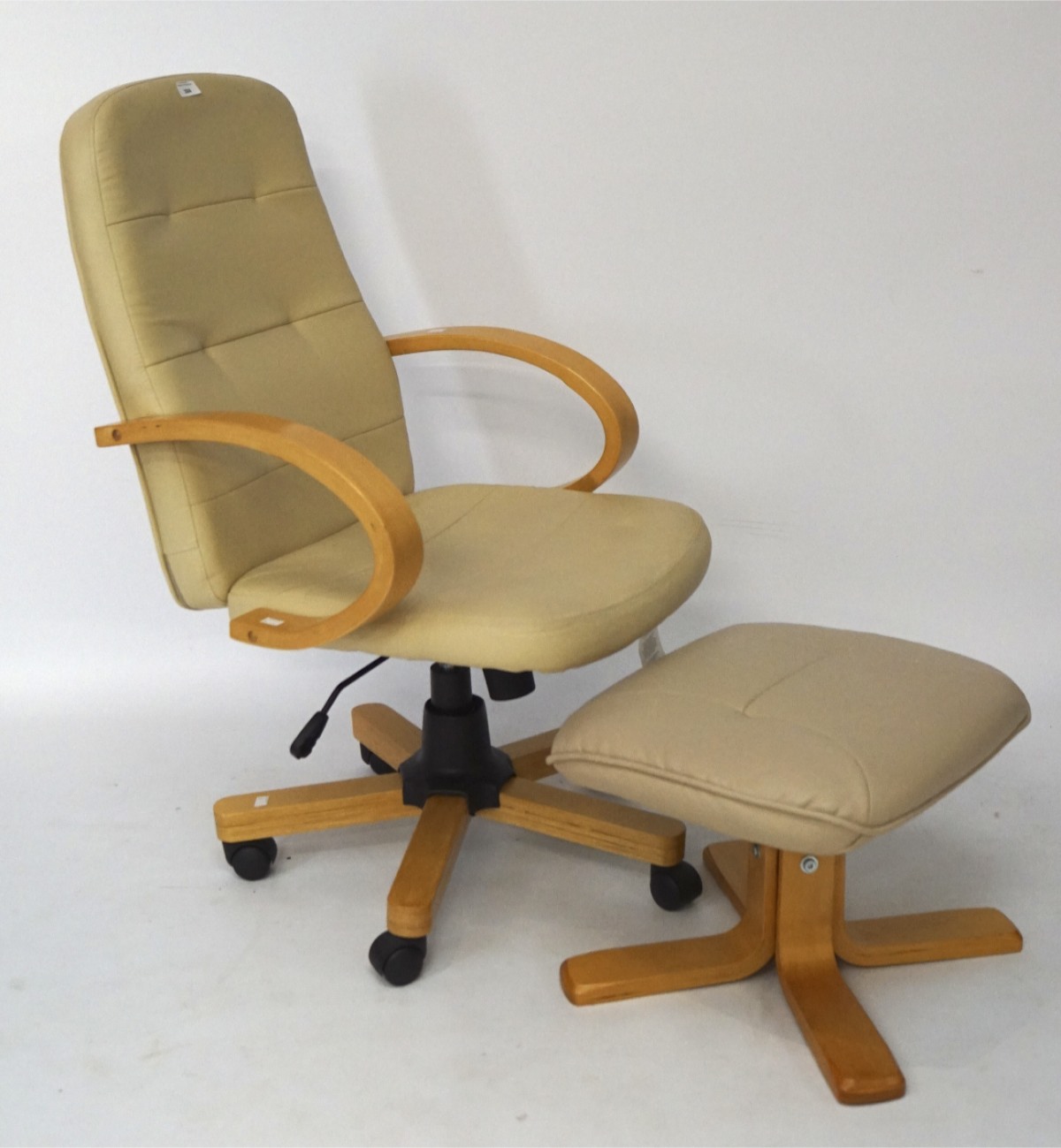 A Retro swivel chair and footstool, upholstered in cream leather with wooden armrests and base,